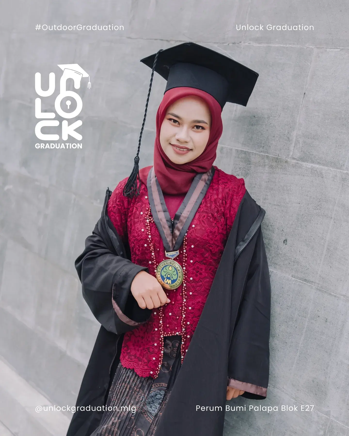 Wisudawati berkebaya merah dengan toga di lorong kampus