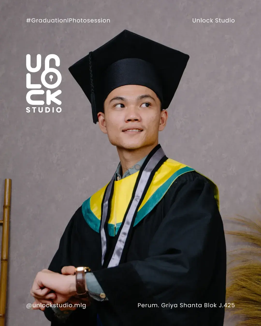 Wisudawan tersenyum dengan toga di studio