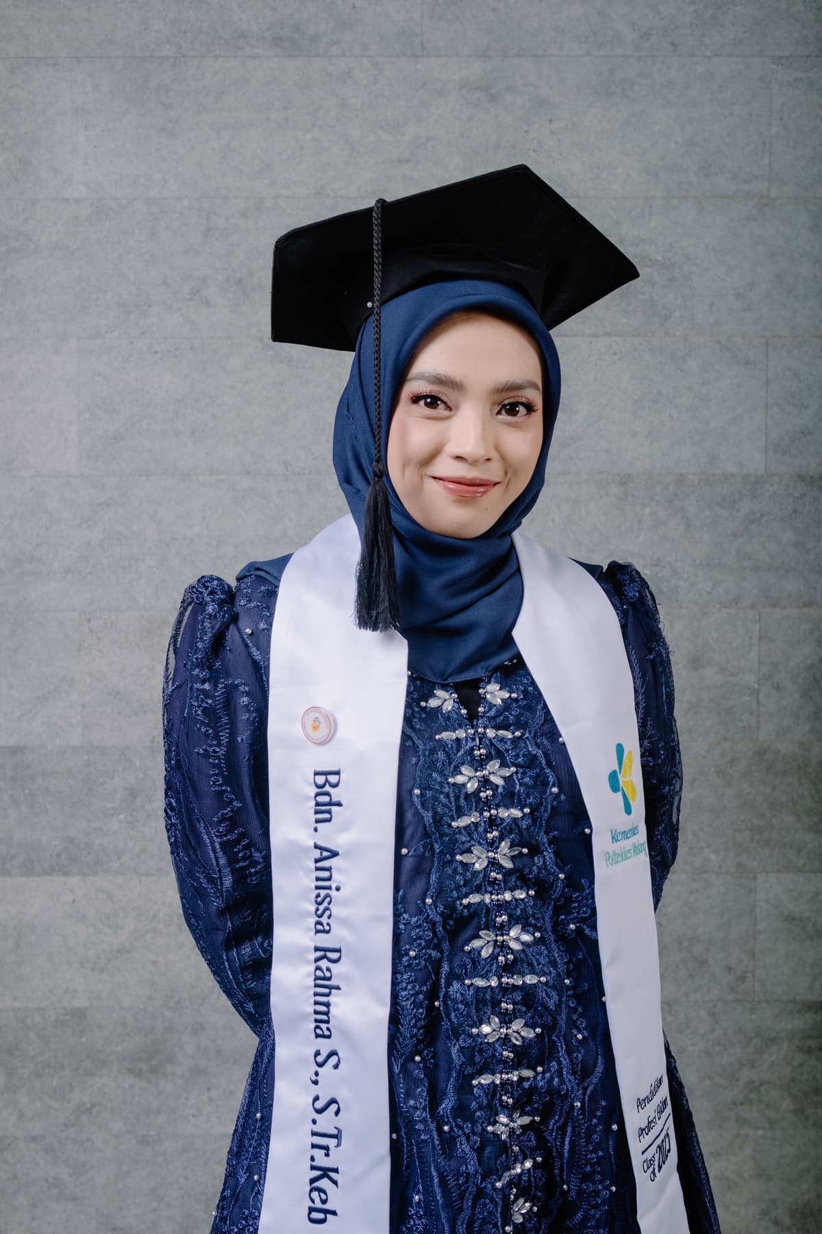 Potret wisudawan dengan selempang dan medali